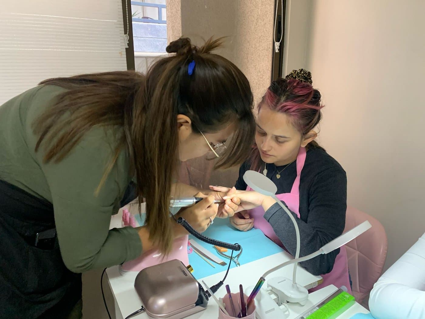 Alumnas trabajando en la mesa de manicure
